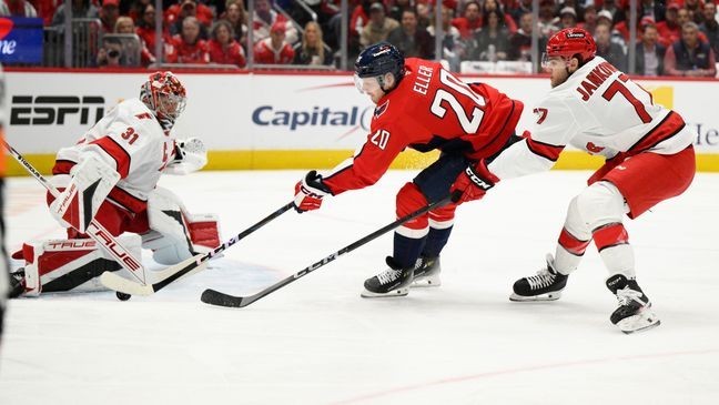 Washington Capitals center Lars Eller (20) tries to get the puck past Carolina Hurricanes goaltender Frederik Andersen (31) and Mark Jankowski (77) during the first period of an NHL hockey game, Thursday, April 10, 2025, in Washington. (AP Photo/Nick Wass)