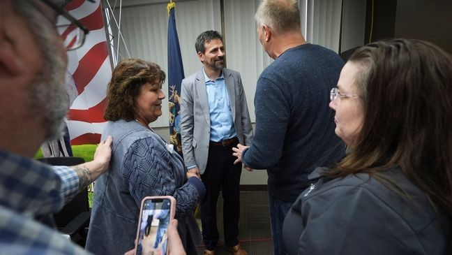 Ryan Kelley, center, speaks with attendees after his talk at the Jackson County Republican headquarters, Thursday, April 10, 2025, in Jackson, Mich. (AP Photo/Paul Sancya)